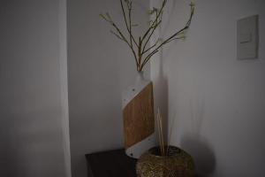 a vase sitting on a table with a plant in it at Affordable Makati APT in Manila