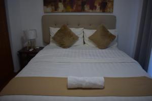 uma cama com um cobertor branco e almofadas em Affordable Makati APT em Manila