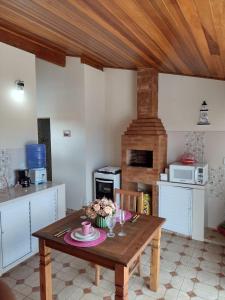 eine Küche mit einem Holztisch mit Blumen darauf in der Unterkunft Apartamento Elite na Cobertura in Cunha