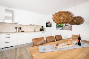 a kitchen with a wooden table with chairs and a counter at Pistenblick Alpin in Sankt Margarethen im Lungau