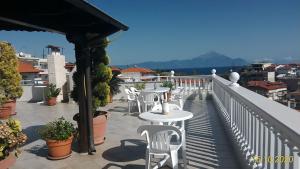 a patio with tables and chairs on a balcony at Haus Despina in Sarti