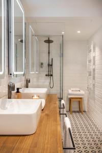 La salle de bains blanche est pourvue d'une baignoire et d'un lavabo. dans l'établissement Cal Roure Boutique Hotel, à Igualada