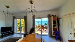 uma sala de estar com uma mesa e vista para o oceano em Bougainvilla Ground floor em Cesme