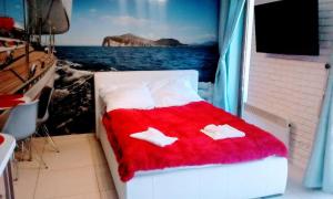 a bed in a room with a red blanket at APARTAMENTY NADMORSKIE STEGNA BALTIC PARK in Stegna