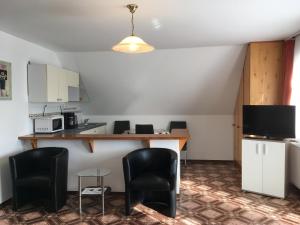 Una habitación con cocina con mesa y sillas. en Gitta Apartman, en Bük