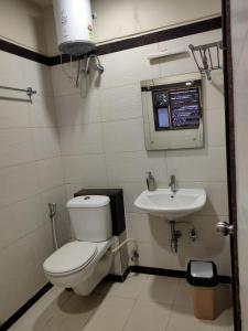 a bathroom with a toilet and a sink at Hotel Rose Mansion Manyata Tech Park in Bengaluru