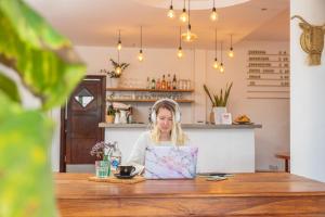 a woman sitting at a table using a laptop computer at Surfescape Fuerteventura in Lajares