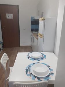 a kitchen with a white table and a refrigerator at SUITEVISTAMARE Copanello-Caminia-Soverato in Copanello