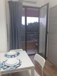 a white table and chairs in a room with a balcony at SUITEVISTAMARE Copanello-Caminia-Soverato in Copanello