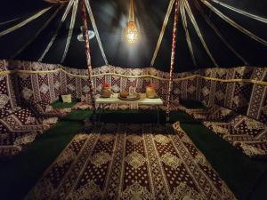 een interieur van een yurt met een tafel met vazen erin bij Crescent Desert Private Camp in Shāhiq