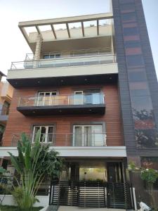 a tall building with a balcony on top of it at Hotel Rose Mansion Manyata Tech Park in Bengaluru