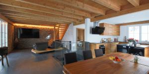 a kitchen and living room with a wooden ceiling at Exklusives Chalet mit traumhafter See- und Bergsicht in Seelisberg