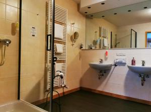a bathroom with two sinks and a shower at Hotel Löwenstein in Gerolstein