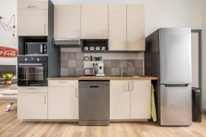 a kitchen with stainless steel appliances and white cabinets at Grand appartement avec 3 salles de bain in Tourcoing