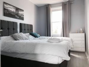 a bedroom with a large white bed and a window at Captivating 2-Bed Apartment in Kirkcaldy in Kirkcaldy