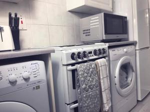 a kitchen with a washing machine and a microwave at Captivating 2-Bed Apartment in Kirkcaldy in Kirkcaldy
