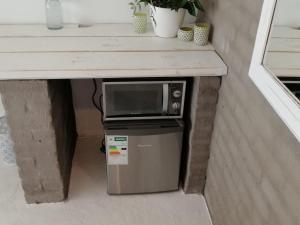 a microwave sitting on top of a refrigerator under a counter at The Last Eve Guesthouse in Douglas
