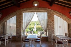 un comedor con mesas y sillas y una gran ventana en SarAnd Relais-Adults Only, en Fondi