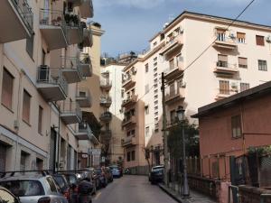 eine Stadtstraße mit geparkten Autos und hohen Gebäuden in der Unterkunft Balzico House in Salerno