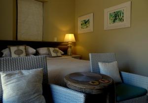 a hotel room with a bed and a table and chairs at La Cabriere Country House in Franschhoek