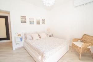 a white bedroom with a bed and a chair at SARA E MELISSA HOUSE LIERNA in Lierna +34 photos