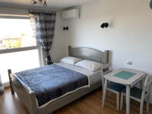 1 dormitorio con cama, mesa y ventana en Studio D, en Poreč