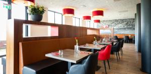 un ristorante con tavoli, sedie e luci rosse di Bastion Hotel Brielle - Europoort a Brielle Altre 29 foto