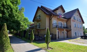 een groot geel gebouw met bomen ervoor bij Ow Alfa in Rewal