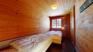 um quarto com duas camas em uma cabana de madeira em Apartment at the bottom of the slopes in Crans-Montana, cosy atmosphere em Crans-Montana