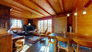 uma sala de estar com uma mesa e uma sala de estar com um sofá em Apartment at the bottom of the slopes in Crans-Montana, cosy atmosphere em Crans-Montana