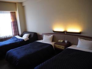 Postel nebo postele na pokoji v ubytování Miyajima Coral Hotel