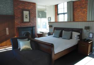 a bedroom with a bed and a chair and a fireplace at Hotel Du Vin Newcastle in Newcastle upon Tyne