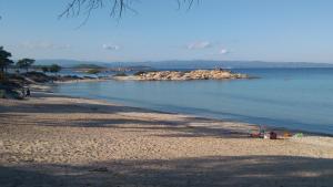 a beach with a group of people sitting on the sand at Haus Despina in Sarti