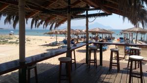 a bar on a beach with chairs and umbrellas at Haus Despina in Sarti