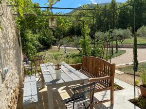 a patio with a table and chairs in a garden at Le Roet in Sisteron