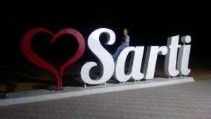 a man sitting on top of a sign with a heart at Haus Despina in Sarti