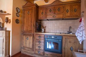 eine Küche mit Holzschränken und einem blauen Backofen in der Unterkunft Isarco Suite in Sterzing + 35 Fotos