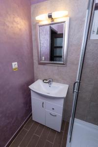 a bathroom with a sink and a mirror and a shower at Pensiunea 1 Mai in Baile Unu Mai +67 photos