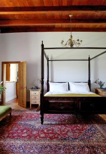 ein Schlafzimmer mit einem Himmelbett und einem Teppich in der Unterkunft Eikehof Farm in Worcester