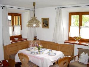 uma sala de jantar com uma mesa com uma toalha de mesa branca em Ferienwohnung Diechtler em Ruhpolding