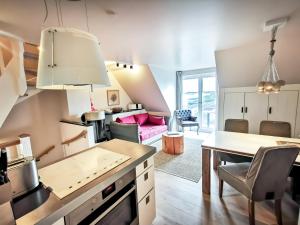 eine Küche und ein Wohnzimmer mit einem Tisch und Stühlen in der Unterkunft Apartmenthaus Gurtdeel 4 in Hörnum
