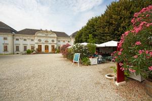 a large white building with flowers in front of it at Knappenstöckl in Halbturn