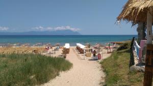 a beach with chairs and umbrellas and the ocean at Haus Despina in Sarti