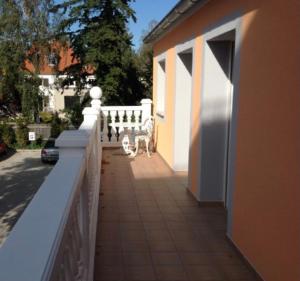 a dog sitting on a porch next to a fence at BEST LONGSTAY INN, homestead and extended stay - KRAL Hotels Erlangen in Erlangen