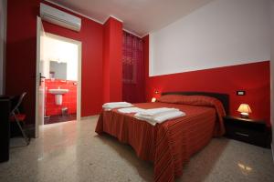 a red bedroom with a bed and a bathroom at B&B Dimora Del Principe in Trapani