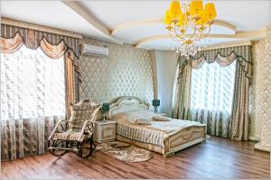 ブリャンスクにあるGostinyi Domのベッドルーム1室(ベッド1台、シャンデリア付)