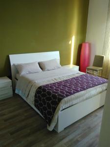 プラートにあるCasa Olgaのベッドルーム1室(大型ベッド1台、紫色の掛け布団付)