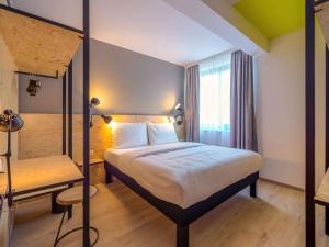 a bedroom with a large bed and a large window at ibis Styles Wien Messe Prater in Vienna