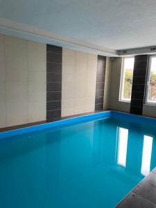 a swimming pool with blue water in a building at CAC Wellness Apartment in Siófok