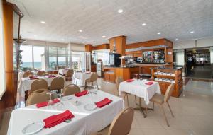 un restaurant avec des tables et des chaises blanches et une cuisine dans l'établissement Rincón Sol, à Rincón de la Victoria